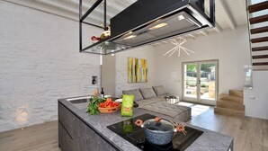 A modern kitchen with a built-in stove, a stone countertop, and a glass backsplash. - Ovile, Fattoria la Pieve, Roccalbegna, Grosseto and Maremma (Roccalbegna)