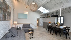 A spacious living area with a high ceiling, a dining table set for four, and a cozy seating area with a sofa and two side tables. - Pievania, Fattoria la Pieve, Roccalbegna, Grosseto and Maremma (Roccalbegna)