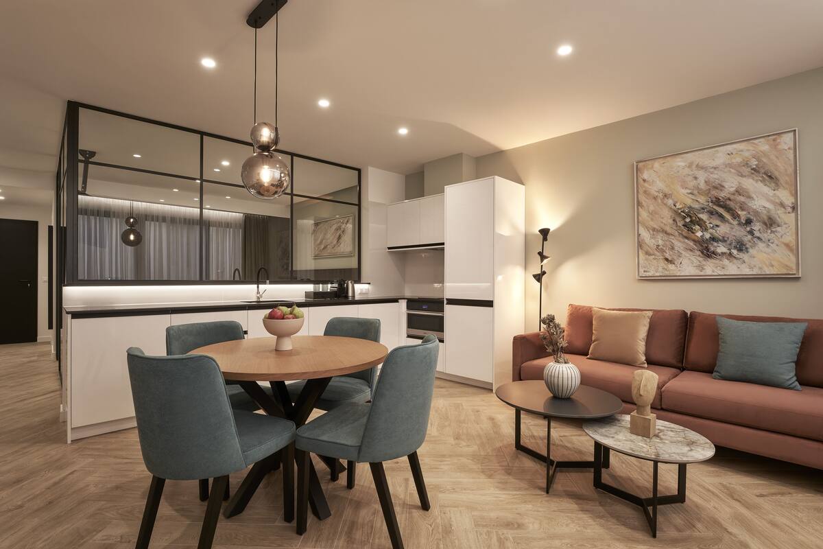 A modern kitchen with a dining area, a sofa, and a coffee table.