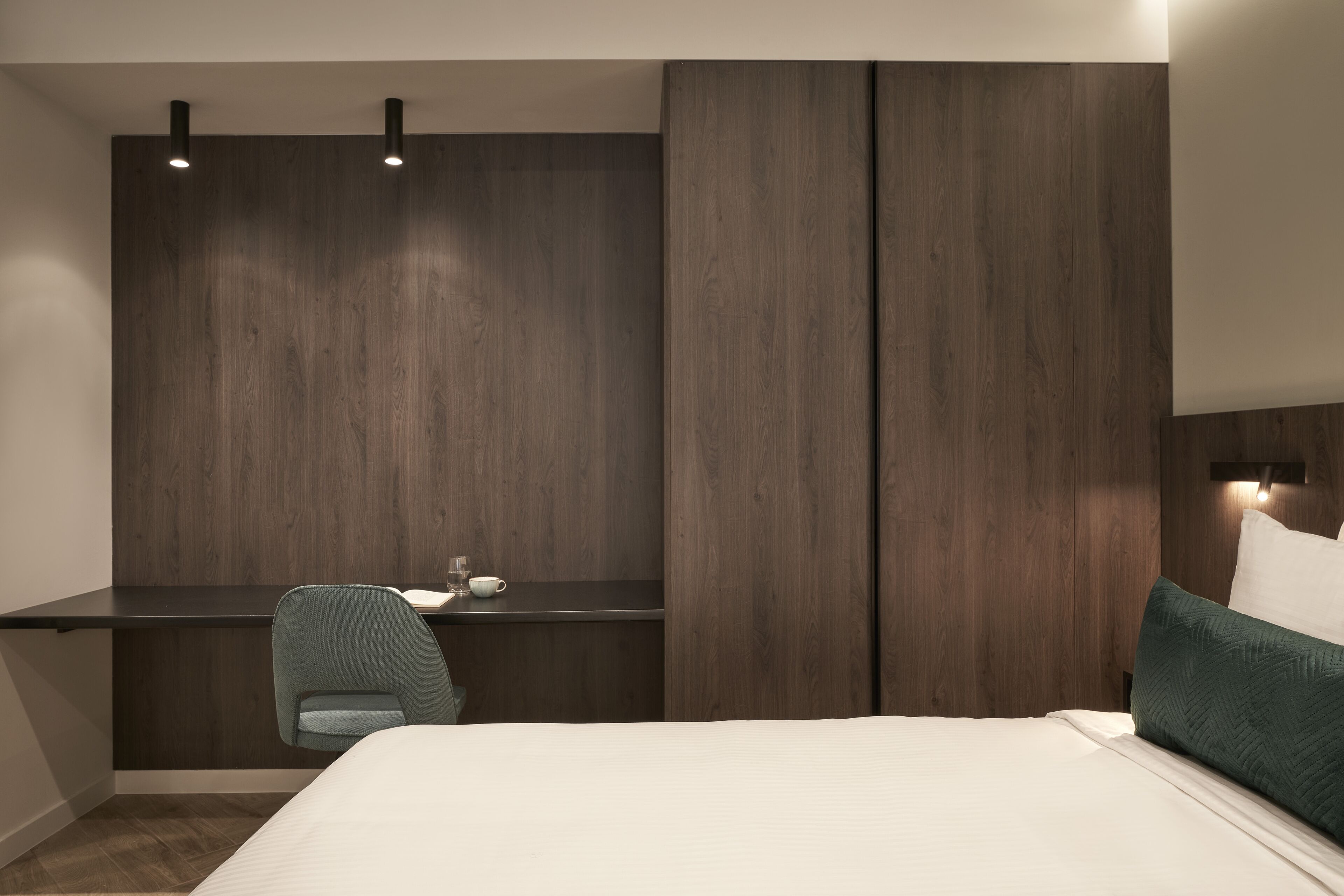 Ein modernes Schlafzimmer mit Bett, Schreibtisch und Stuhl.