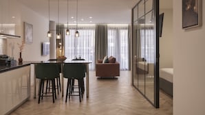 A modern kitchen with a dining area, a sofa, and a glass partition. - Hestia - Dimitressa 4 (Athens)