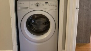 Une machine à laver et un sèche-linge superposés dans une buanderie.