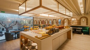 A breakfast buffet with various food items and seating arrangements. - Luster Hotel (Lisbon)