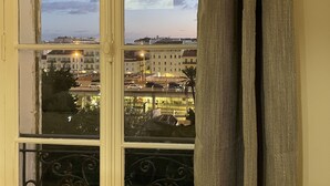 Una finestra con vista su un paesaggio urbano al crepuscolo, che include edifici e un ponte.