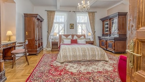 A spacious bedroom with a large bed, wooden furniture, and a chandelier. - Treasure Of The Past With Whirlpool (Balatonrendes)