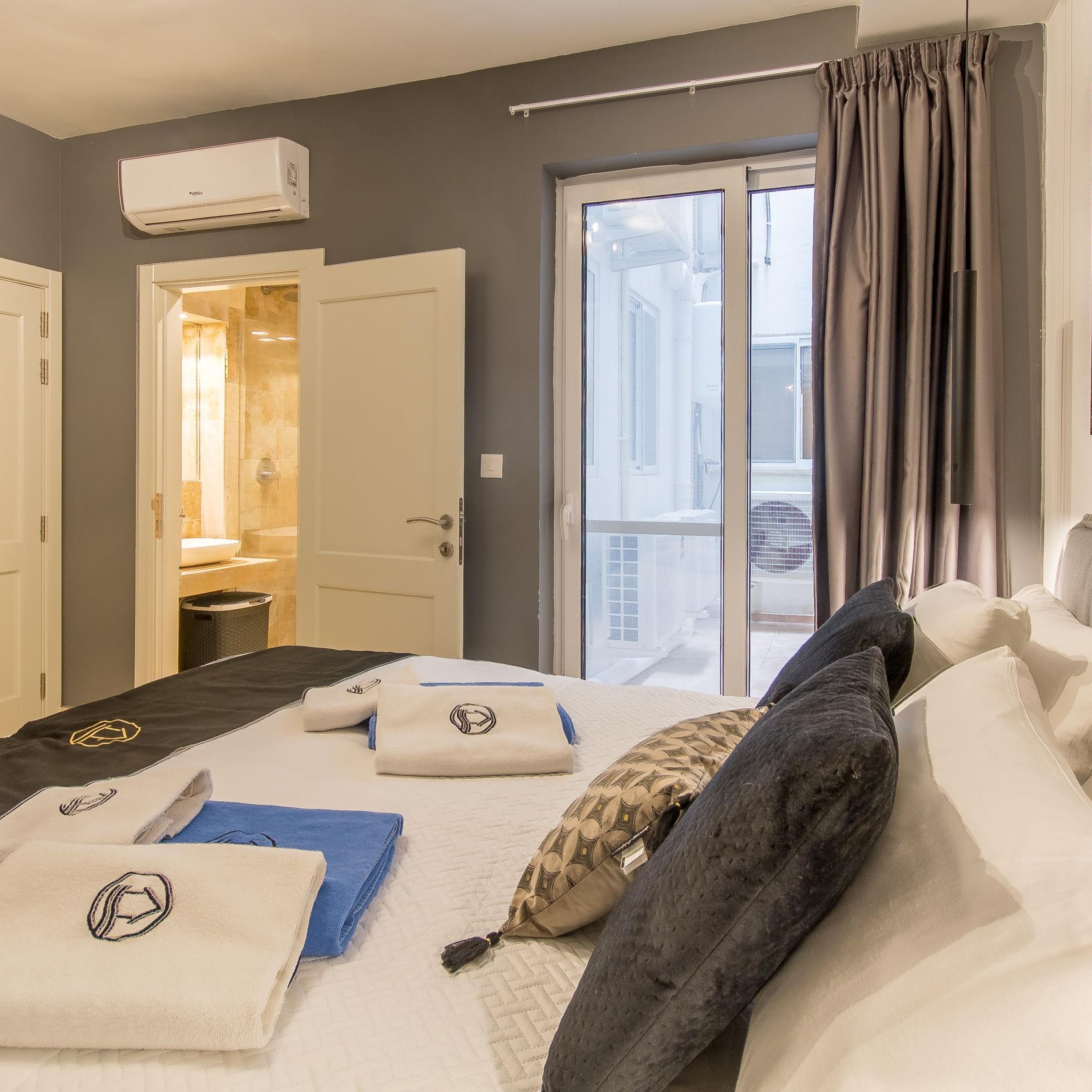 Habitación de hotel con cama, toallas y vistas al exterior.