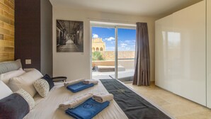 Habitación de hotel con una cama, un ventanal y vistas a un edificio.