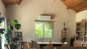 A spacious living room with a wooden ceiling, a dining area, and a large window providing natural light. - Villa overlooking the countryside (La Chapelle-Saint-Sauveur)