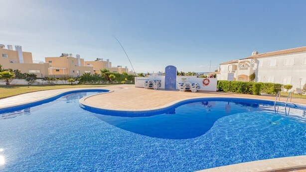 A swimming pool with a tiled deck, a lifebuoy, and a blue decorative feature. - Magnificent 2 bedroom ground floor apartment, wi-fi, pool, garden, near beach and golf - Galé, Albufeira (Albufeira)
