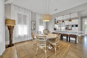 Une cuisine moderne avec des armoires blanches, un four encastré et un grand îlot central.
