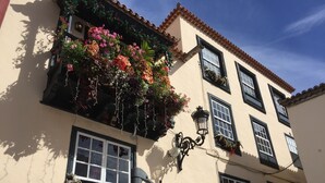 Un bâtiment sur lequel on peut lire l’inscription « LA PLACETA Restaurante », et qui possède un balcon orné de plantes suspendues.