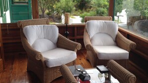 Un coin salon confortable, avec des fauteuils en osier et une table basse, offrant une vue panoramique.