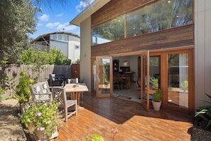 A modern house with a deck, sliding glass doors, and a barbecue area. - The Ancient Mariner Retreat (Cape Woolamai)