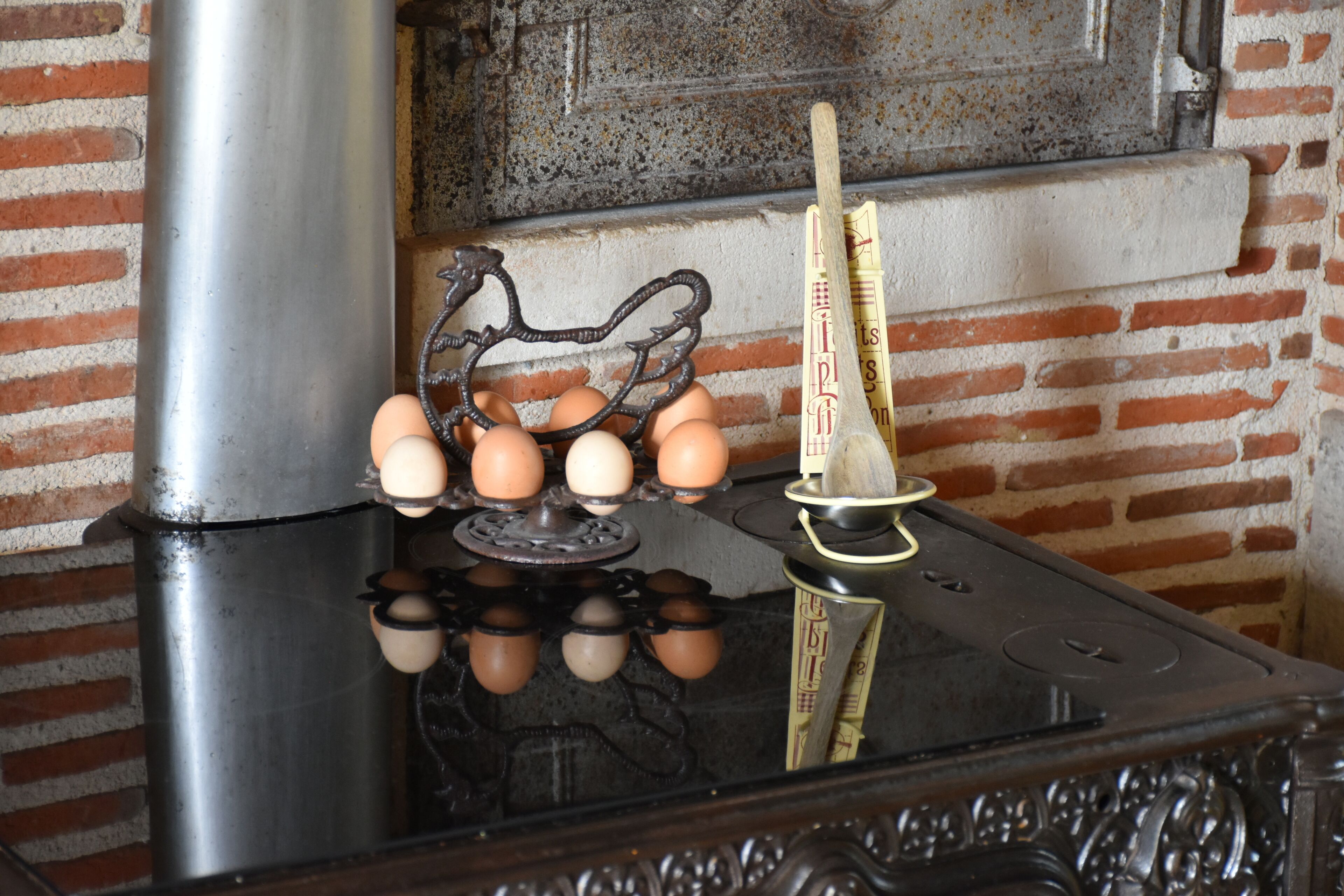 A kitchen with a stove, eggs, and a measuring cup.