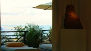 Ein Zimmer mit Meerblick, einer Statue und einem Tisch mit einer Schale.