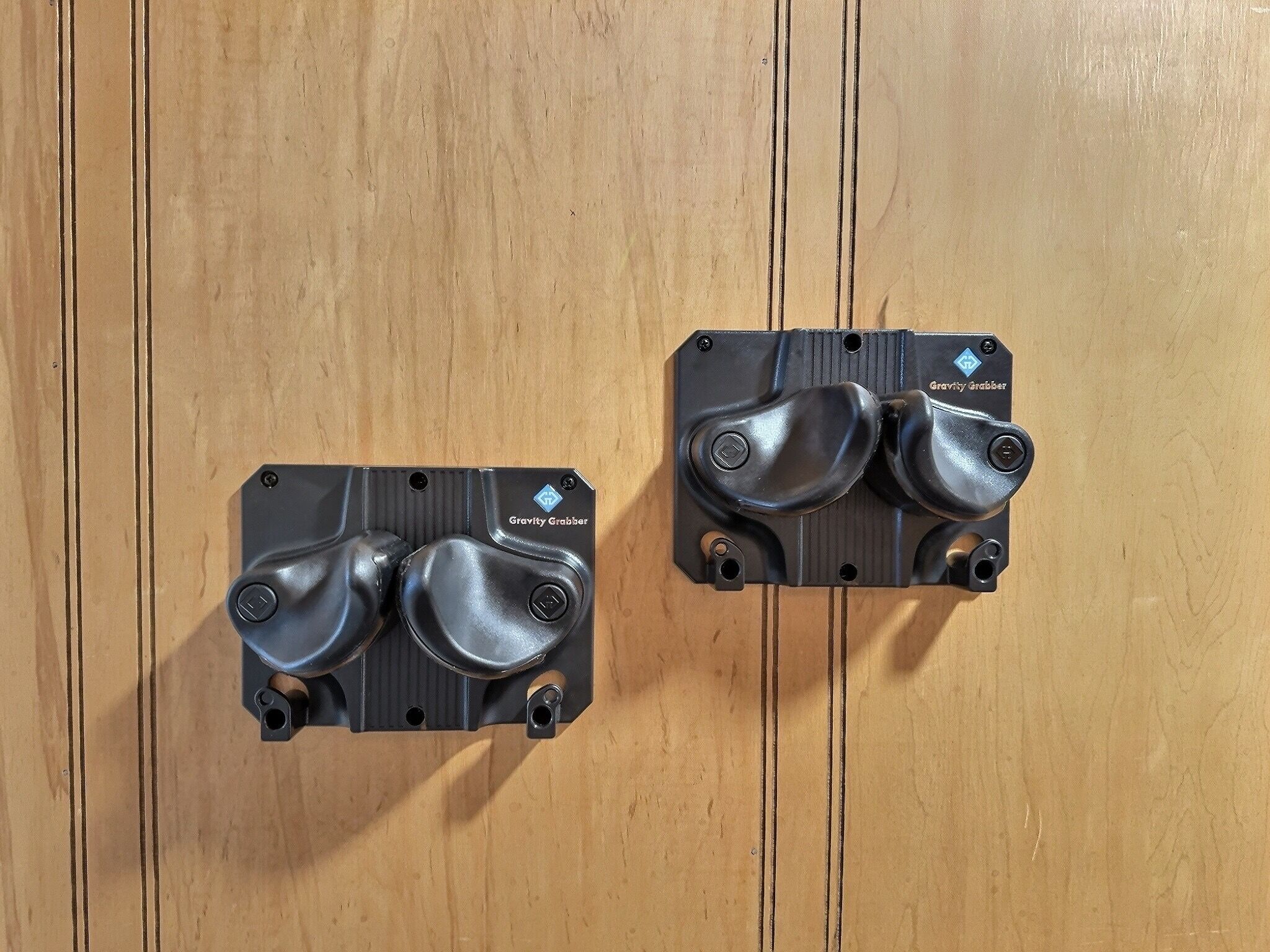 Two Gravity Grabber devices mounted on a wooden surface.