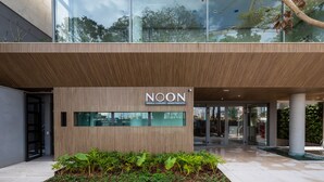 Un edificio moderno con un letrero que dice 'NOON SMALL LUXURY APARTMENTS'.