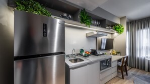 Una cocina moderna con electrodomésticos de acero inoxidable, un lavamanos empotrado y una zona de comedor con una silla y mesa.