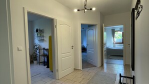 A spacious hallway with tiled flooring, white walls, and a ceiling light fixture. - Ole School apartment in Jork in the middle of the Altes Land (Jork)