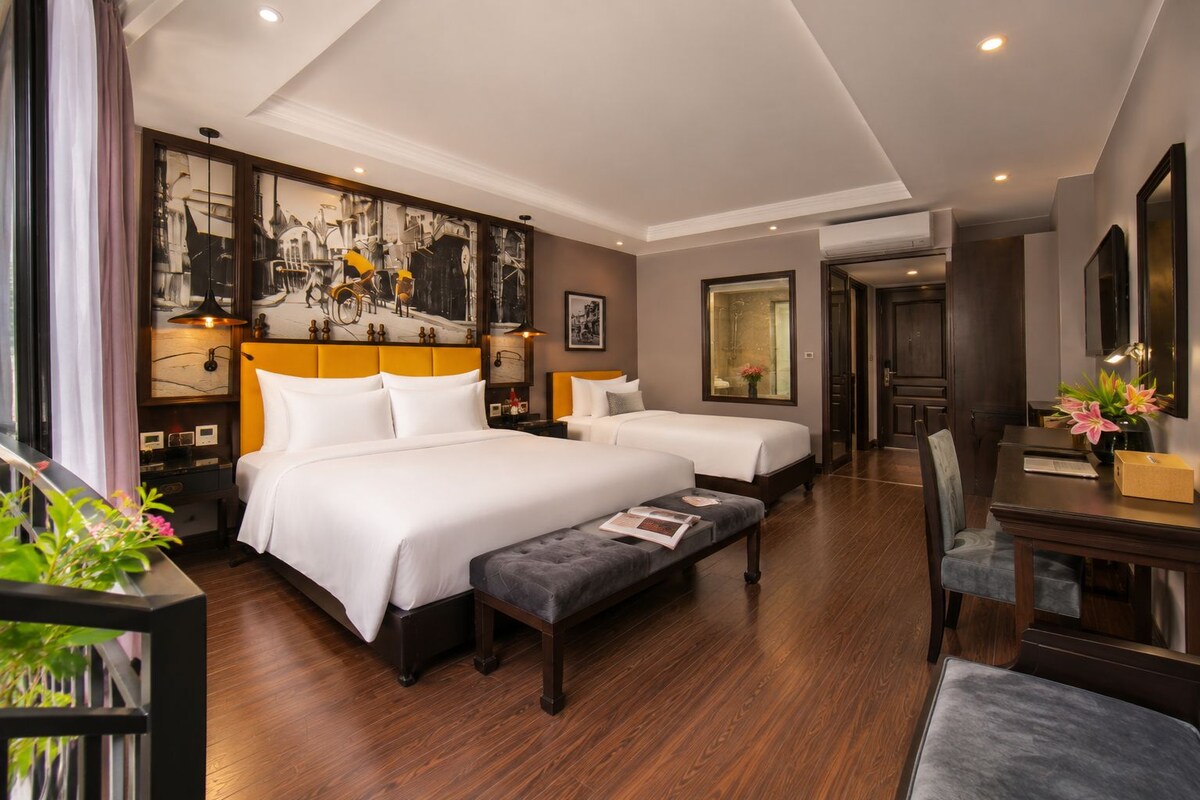 Une chambre d’hôtel avec deux lits, un coin repas et une salle de bain.