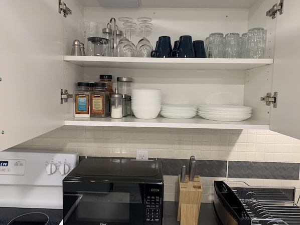 A kitchen with a microwave, a coffee maker, and a knife block on the counter.
