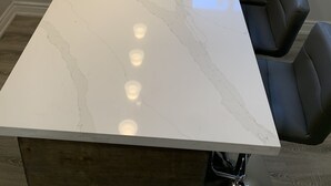 A kitchen with a white marble countertop, a stainless steel sink, and a black leather chair. - Luxury 2 bedroom house - fully renovated - full feature (Richmond Hill)