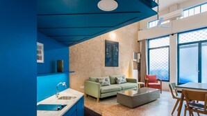 A modern living room with a sofa, coffee table, and dining area. - Architect designed studio (EP7L). Green rooftop! (Athina)