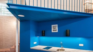 A modern kitchen with blue walls, a marble countertop, and a stainless steel sink. - Architect designed studio (EP7L). Green rooftop! (Athina)