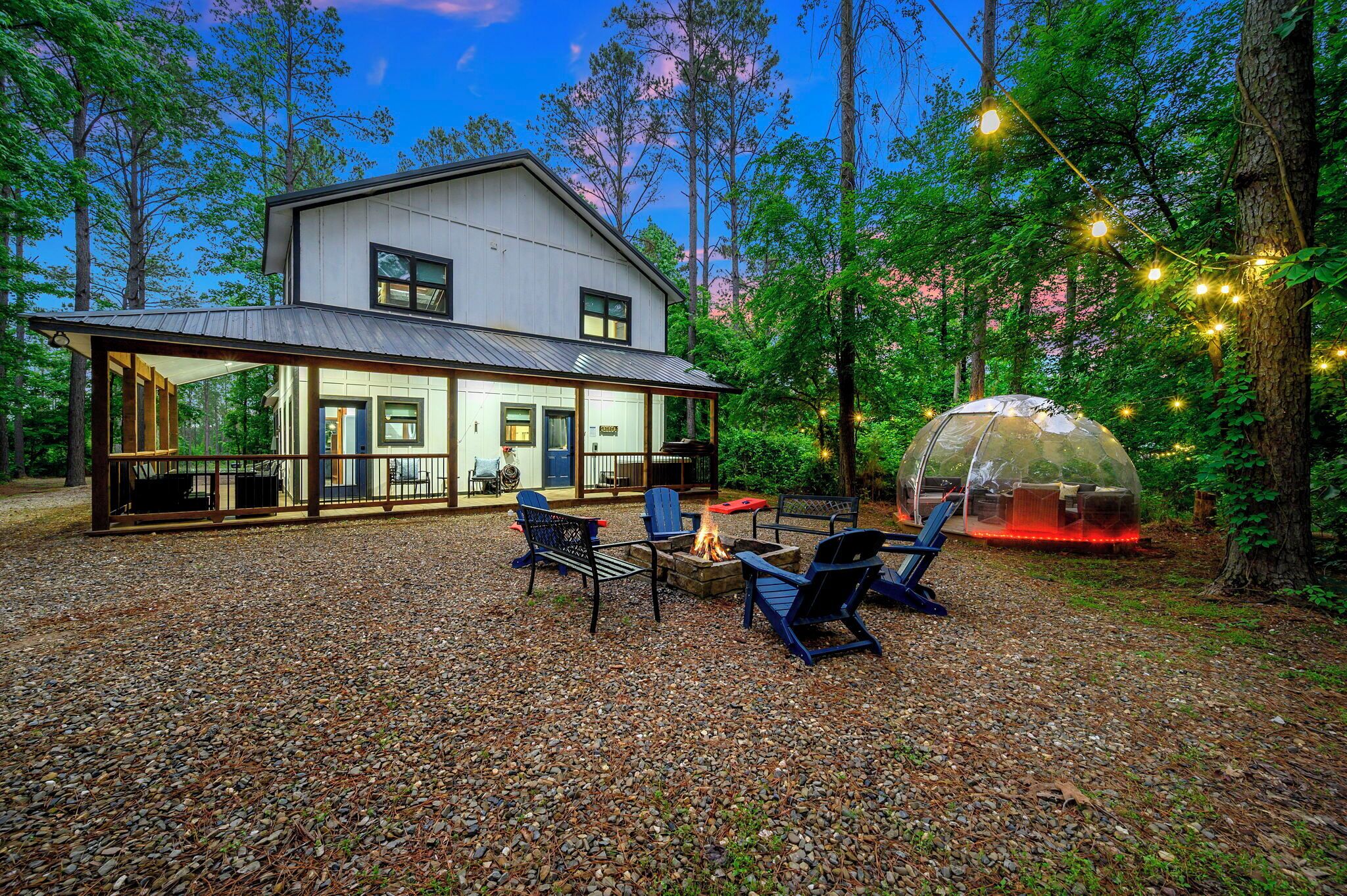 A house with a covered patio, outdoor seating, and a fire pit.