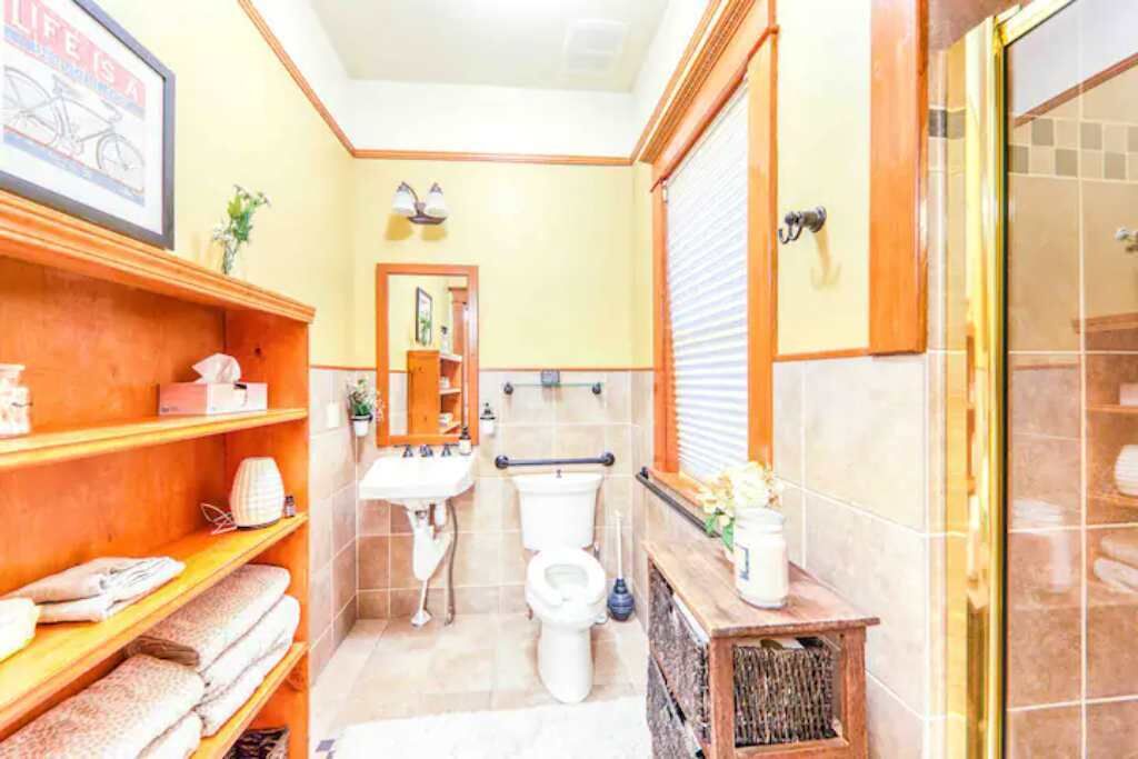 Une petite salle de bain comprenant des toilettes, un lavabo et des étagères avec des serviettes.
