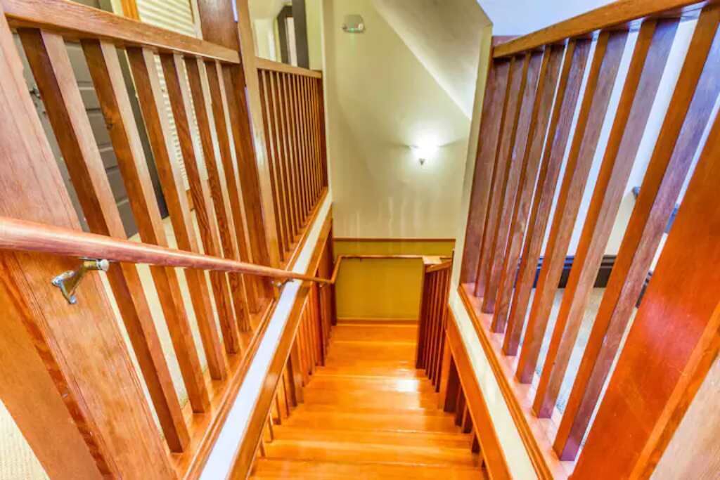 Una scala in legno con corrimano, che conduce a un piano superiore.