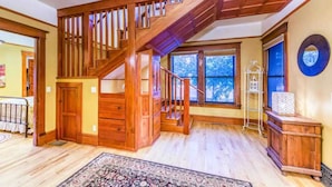 A spacious room with a wooden staircase, a large window with a view, and a decorative mirror on the wall. - The Lovemore Grand Retreat (Delta)