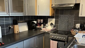 Uma cozinha moderna com eletrodomésticos de aço inoxidável, piso xadrez e painel de azulejos.