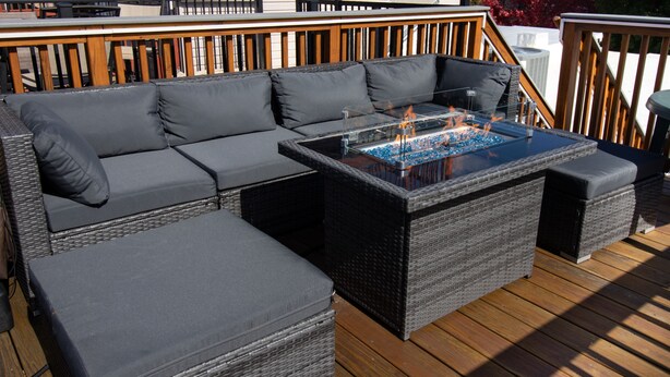 A deck with a large sectional sofa and a glass-top coffee table with a fire feature. - Modern Smart Home w/Gourmet Kitchen, Peloton & King Suite  with Rooftop Deck (Baltimore)