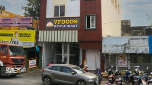 Un edificio de varios pisos con un letrero que dice HOTEL VI PARK y un restaurante VFOODS.