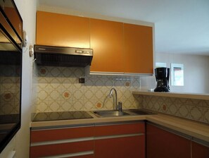 Enjoy cooking in this well-equipped kitchen with a stainless steel sink, range hood, and coffee maker.