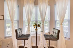 Una habitación con dos sillones de cuero, una mesa de vidrio y un jarrón con flores.