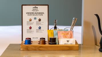 Una bandeja de madera con café y opciones de té, un letrero de Walthaus bei der Basel y una máquina de café.