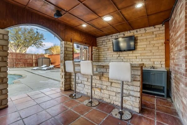 Pull up a stool at the covered outdoor bar for a cold drink and conversation between backyard activities.