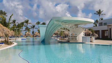 A swimming pool with a modern structure, palm trees, and lounge chairs.
