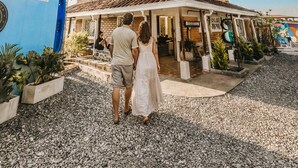 A two-story house with a tiled roof, a porch, and a palm tree in the background. - La Madriguera Hotel Guatapé Con Embalse (Guatapé)