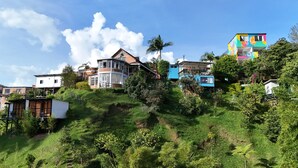A hillside residential area with various houses, including a colorful building with a balcony. - La Madriguera Hotel Guatapé Con Embalse (Guatapé)