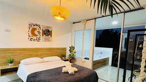 A modern bedroom with a large bed, a hanging light fixture, and a view of the outside. - La Madriguera Hotel Guatapé Con Embalse (Guatapé)
