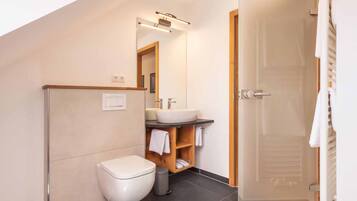 Un baño moderno con inodoro, lavabo y espejo.