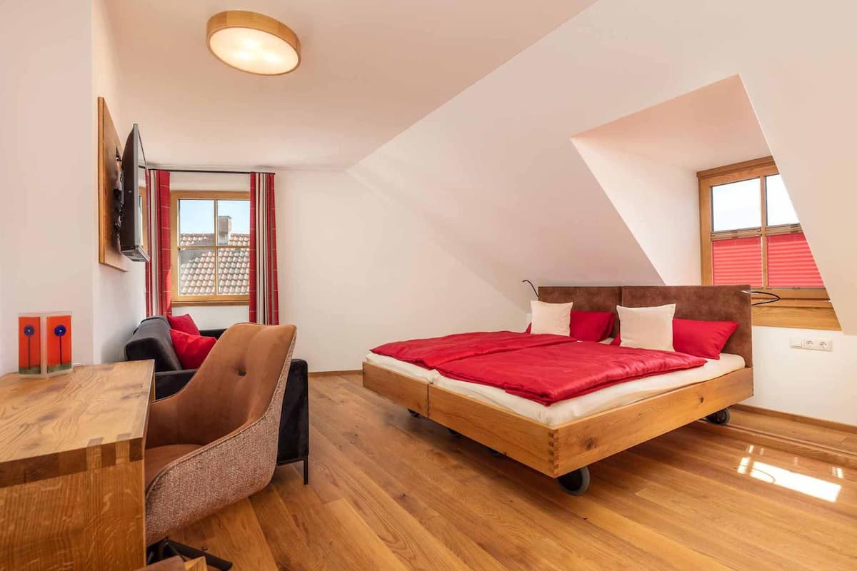 Une chambre à coucher avec un lit en bois, un bureau et une chaise.