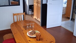 Un coin repas avec une table en bois, des chaises et une assiette de nourriture.