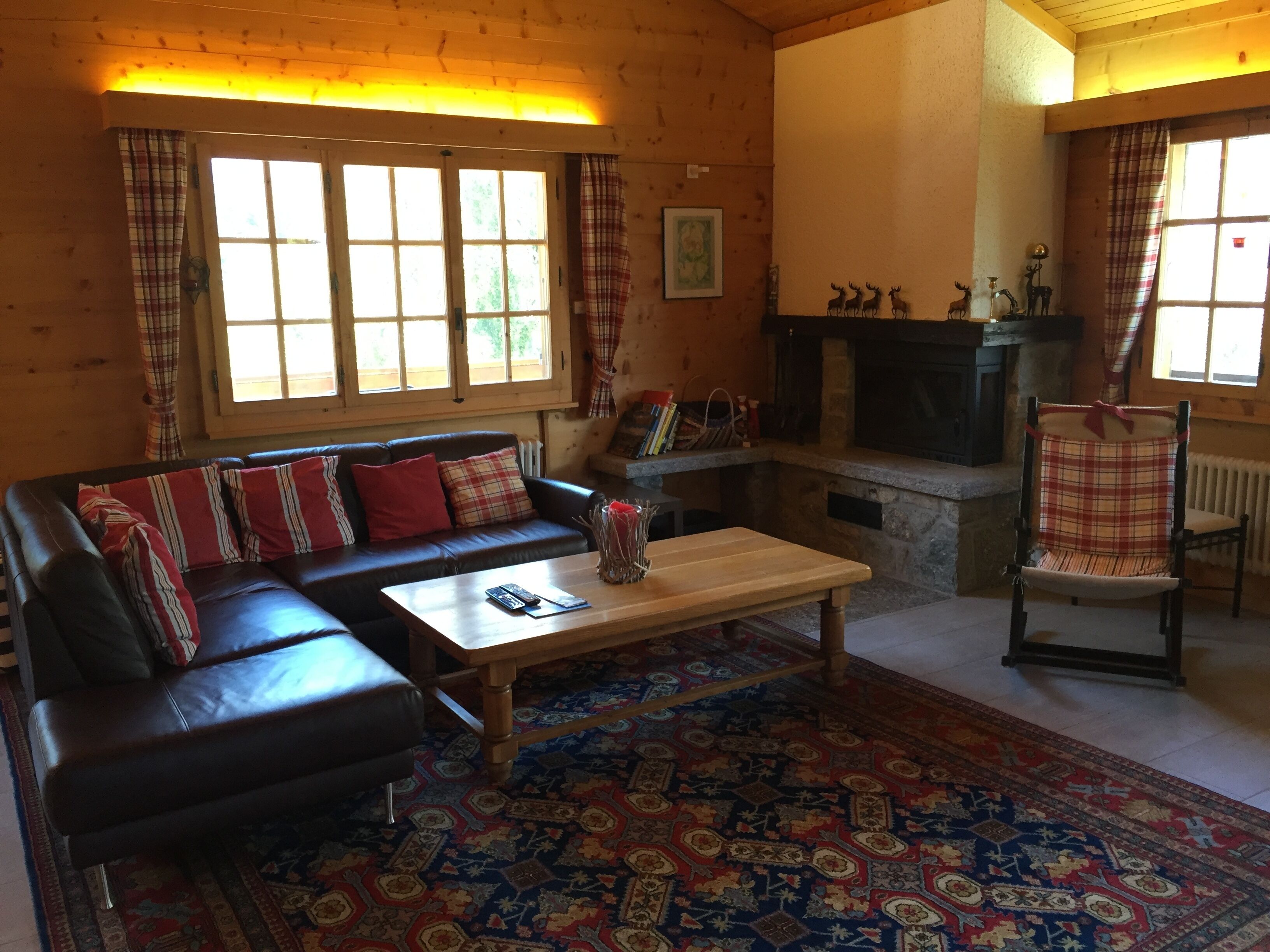 Una sala de estar acogedora con un sofá de cuero, una mesa de centro de madera y un tapete estampado.
