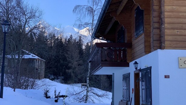 A wooden chalet with a balcony, a snow-covered ground, and a mountain backdrop. - Luxury chalet (approx. 170 sqm) in a dreamlike mountain setting - Valais (Grächen/near Zermatt) (Niedergrächen)