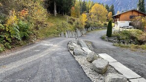 A paved road with a stone border, surrounded by autumn foliage and a mountain backdrop. - Luxury chalet (approx. 170 sqm) in a dreamlike mountain setting - Valais (Grächen/near Zermatt) (Niedergrächen)