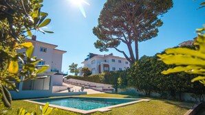Un quartier résidentiel avec une piscine, un grand arbre et une maison à plusieurs étages.